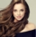 Young, brown haired woman  with voluminous hair.Beautiful model with long, dense, curly hairstyle and vivid makeup. Perfect dense, wavy,and shiny hair. Hairdressing art, hair care and beauty products.